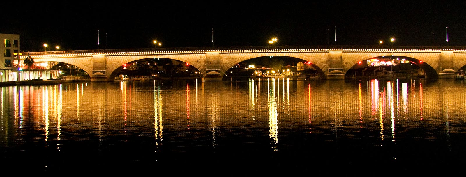 London Bridge at night, lights reflected on still water