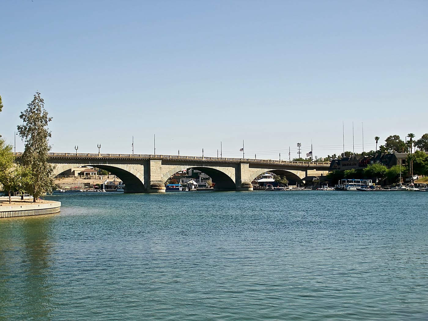 London Bridge at Lake Havasu framed by palms, calm channel in front of the arches