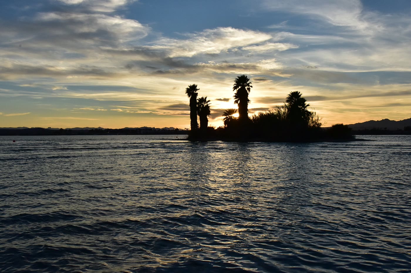 Golden sunset over glassy Lake Havasu with desert mountains along the shore