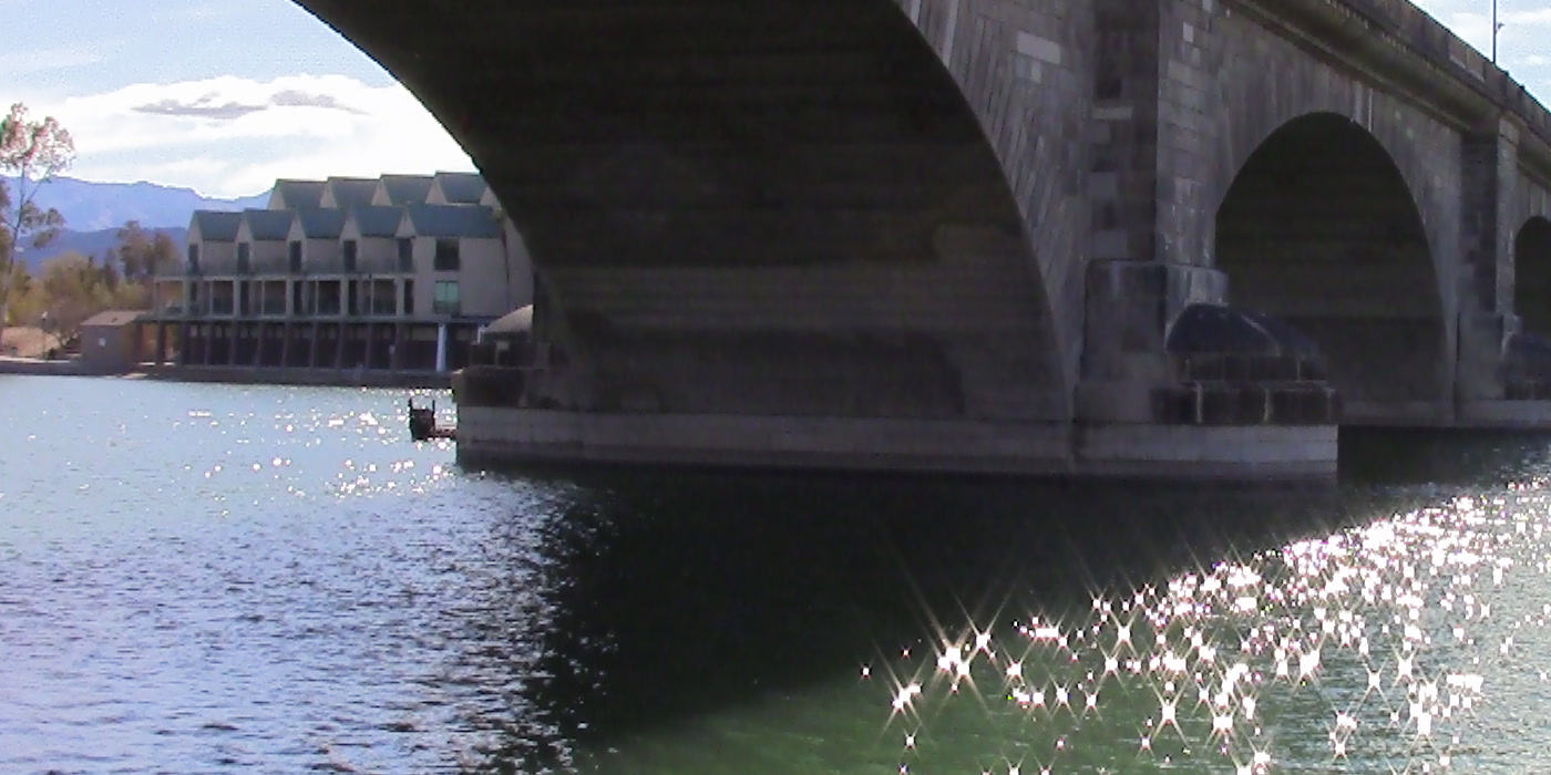 London Bridge at Lake Havasu, stone arches over calm water with desert mountains behind